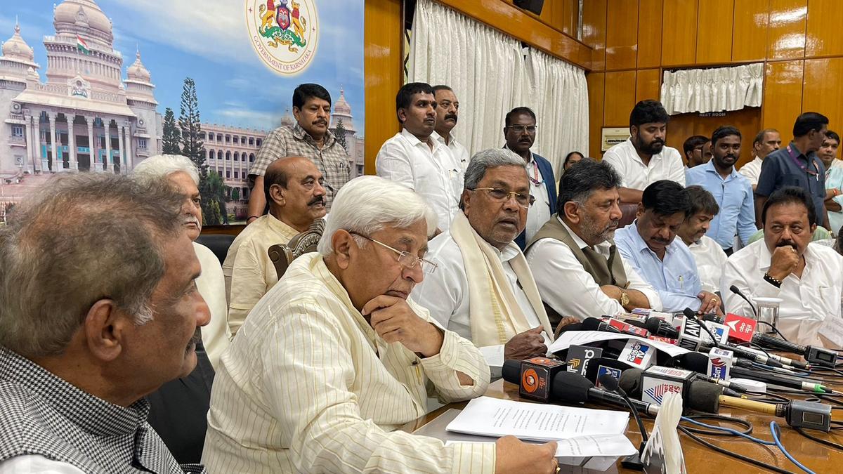 a group of men sitting at a table with microphones